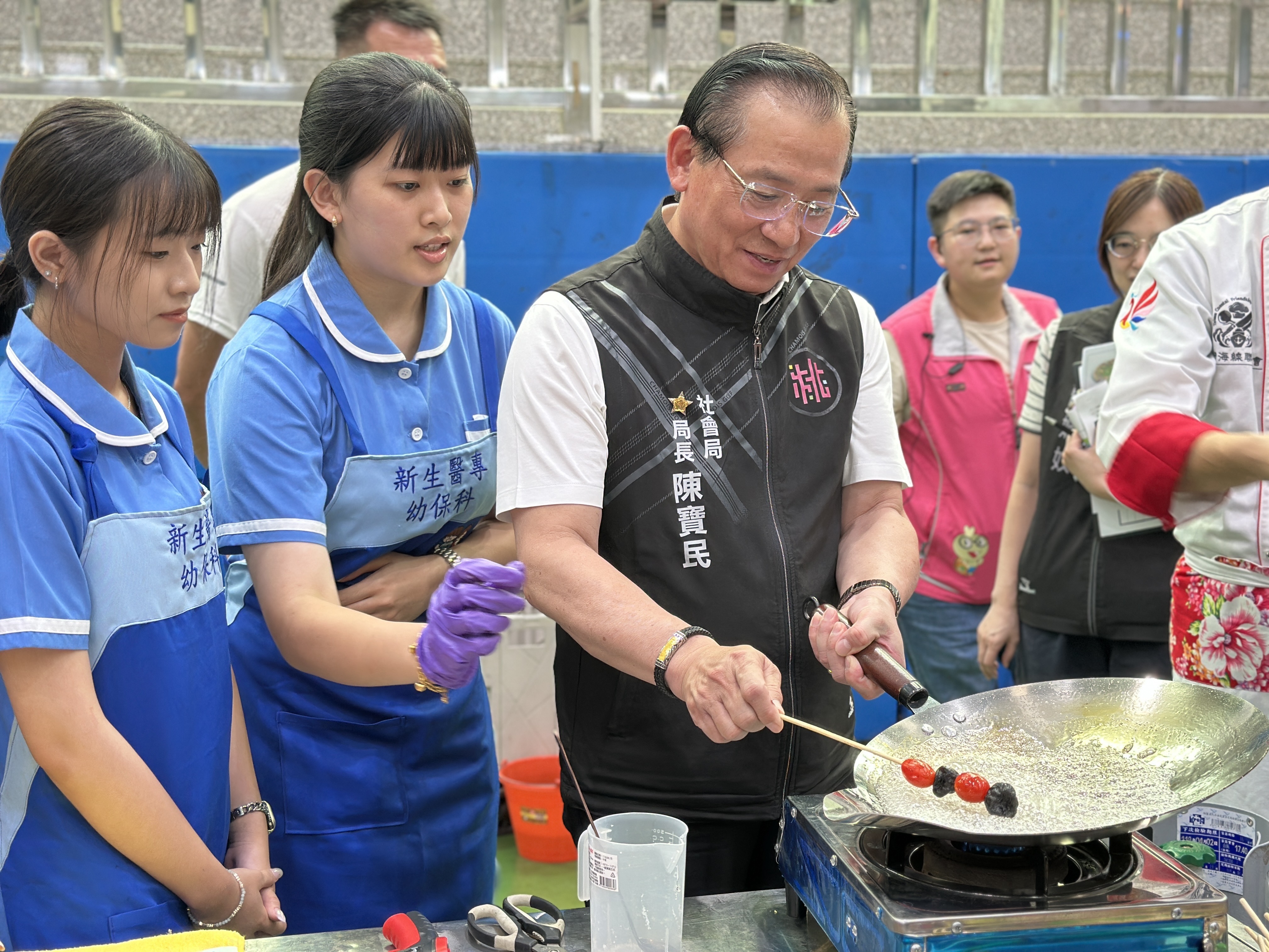 桃園市社會局局長陳寶民體驗「手作糖葫蘆」。圖：新生醫專提供